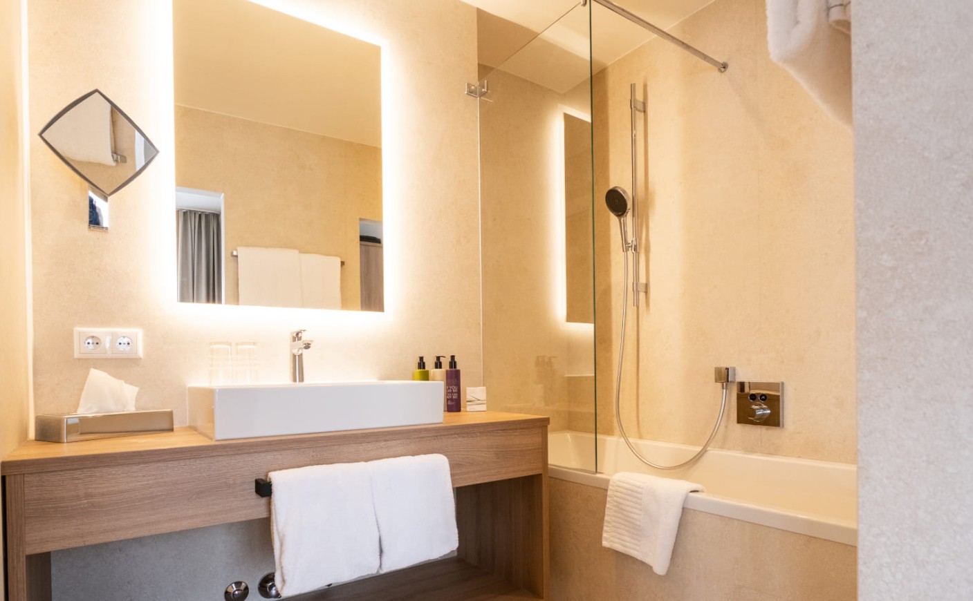 Badezimmer mit Regendusche und Waschtisch im Doppelzimmer Deluxe mit Balkon