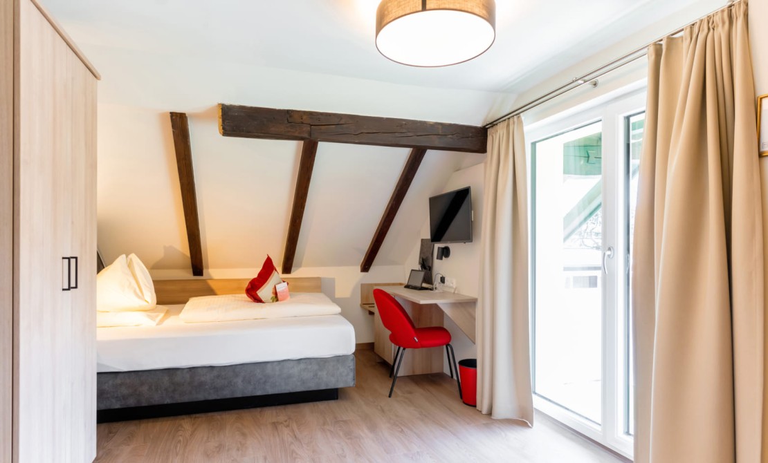 Einzelzimmer in der Rosenvilla Salzburg mit Balkon und stilvoller Einrichtung