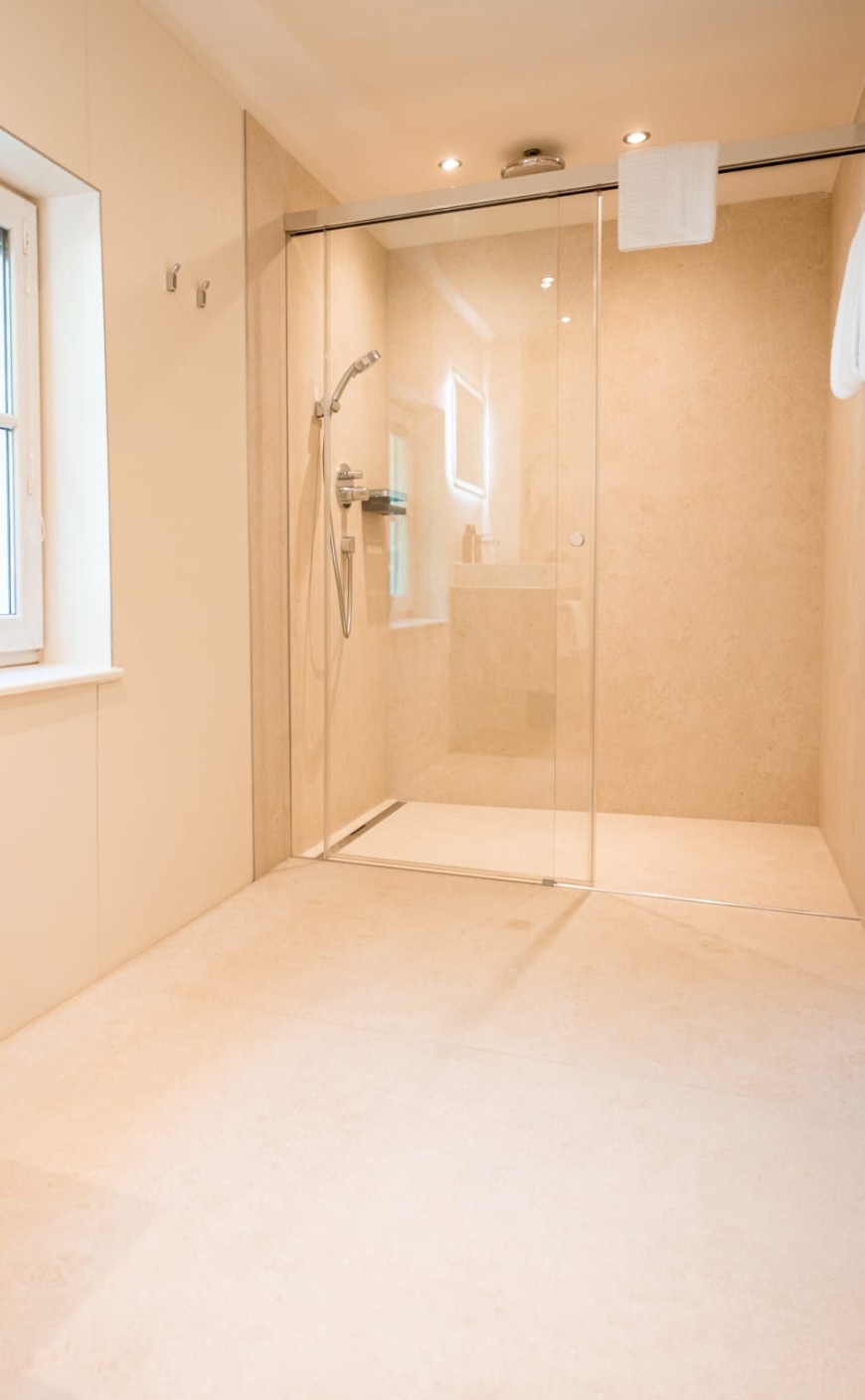 Badezimmer mit Regendusche und Tageslicht in der Junior Suite in Salzburg