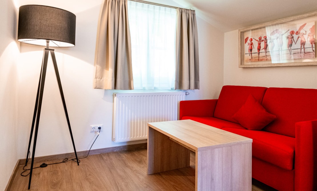 Sitzecke mit Sofa und Designleuchte in der Junior Suite
