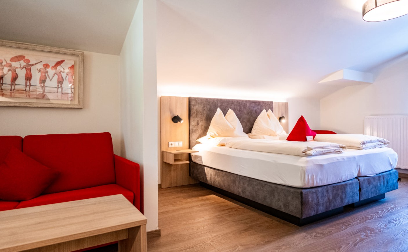 Junior Suite in der Rosenvilla Salzburg mit gem&uuml;tlichem Doppelbett und Sitzecke